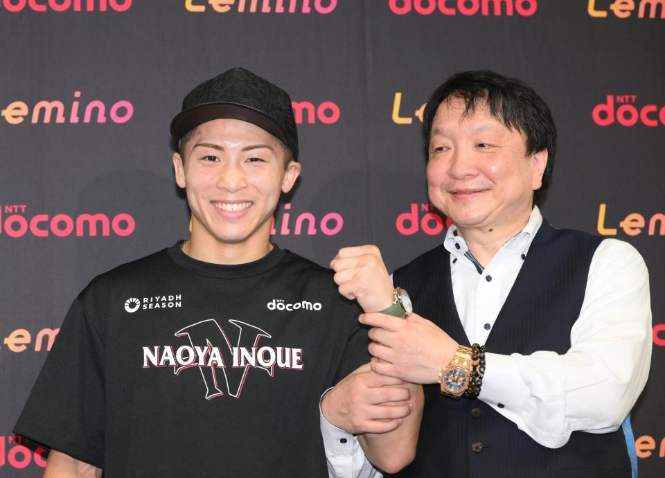 　大橋秀行会長（右）に左腕を握られて笑顔になる井上尚弥（撮影・堀内翔）