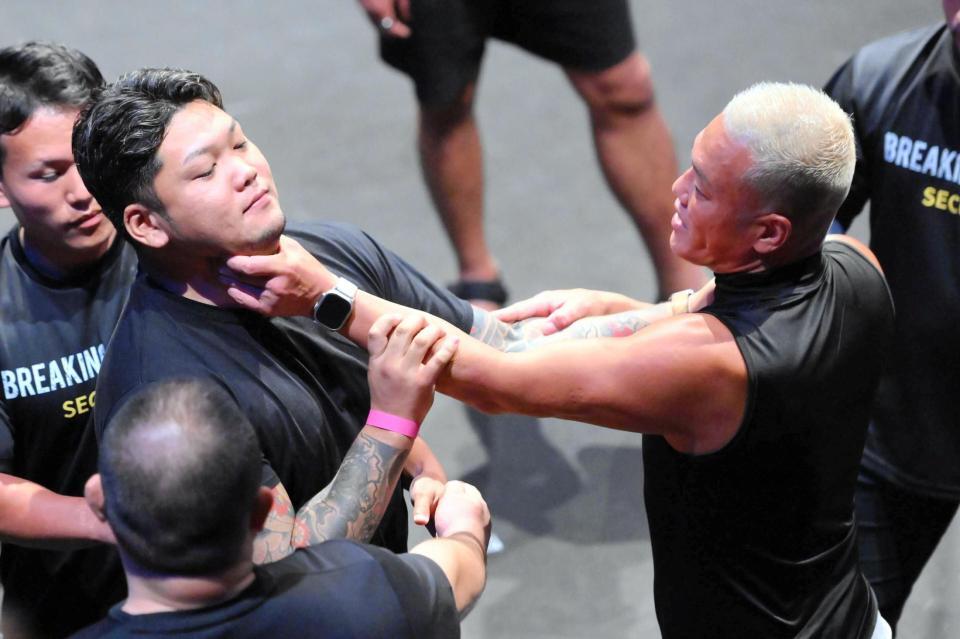 　掴み合いとなるアンディ南野（右）と松井健（左）