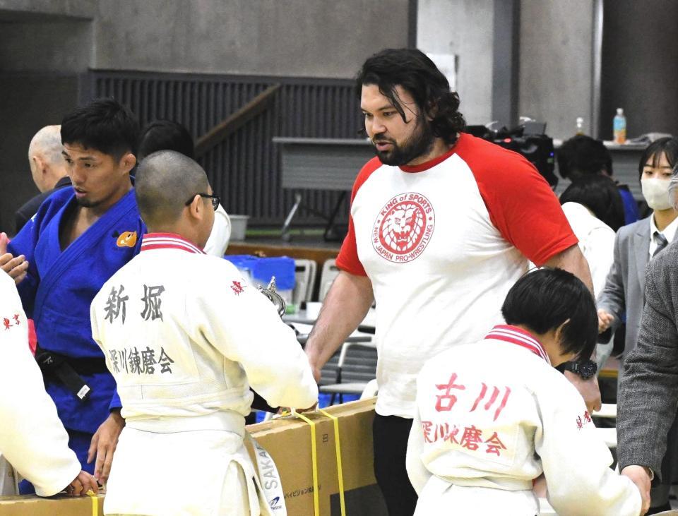 　新日本プロレスＴシャツを着て小学生大会のゲスト解説を務めたウルフ・アロン（中央）。優勝チームの選手に副賞のテレビを手渡す