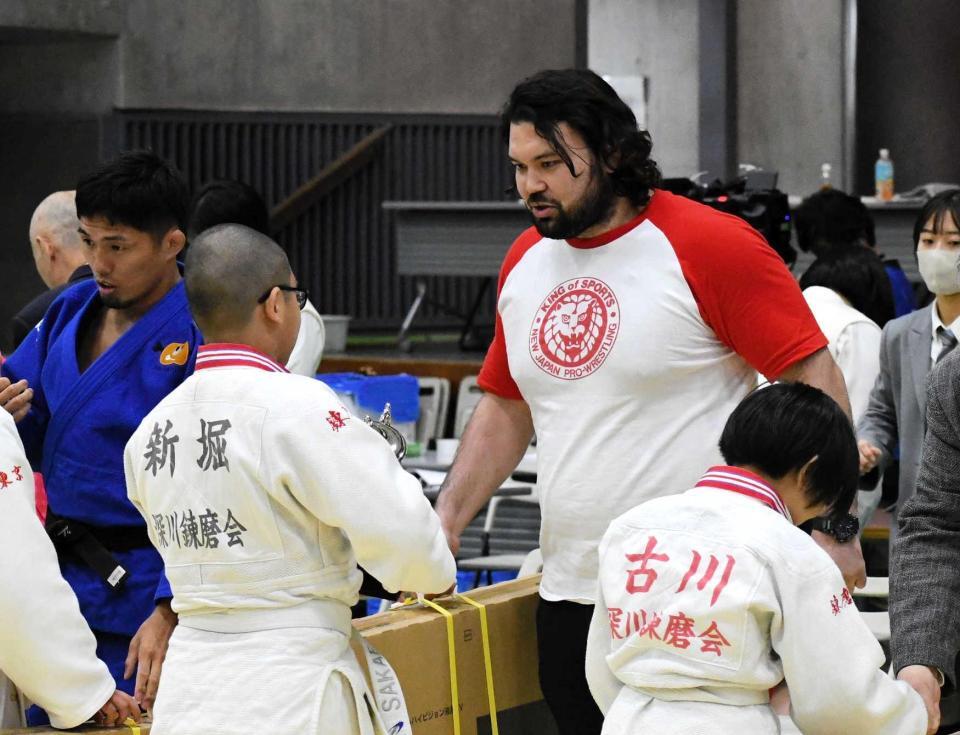 　新日本プロレスＴシャツを着て小学生大会のゲスト解説を務めたウルフ・アロン（中央）。優勝チームの選手に副賞を手渡す