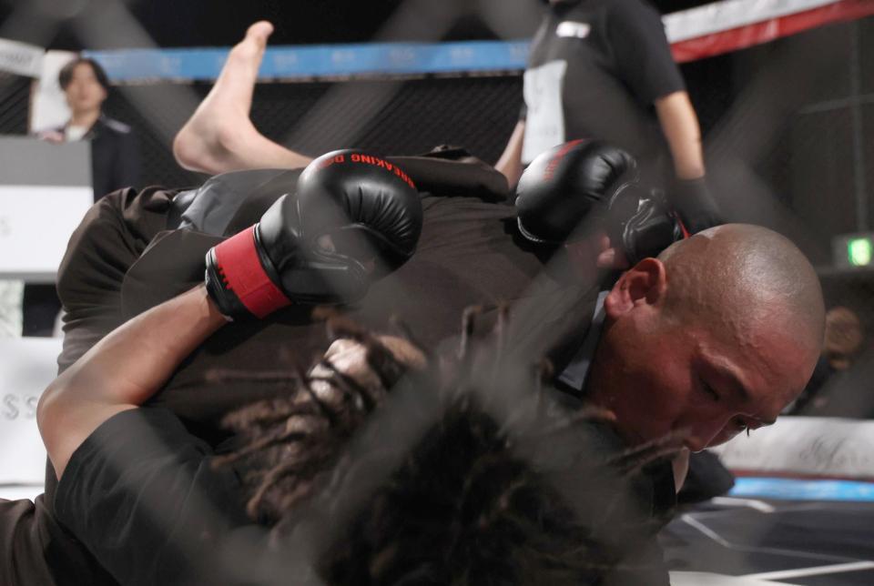 　試合後、ドラゴン（下）を襲撃した村田将一（撮影・佐々木彰尚）