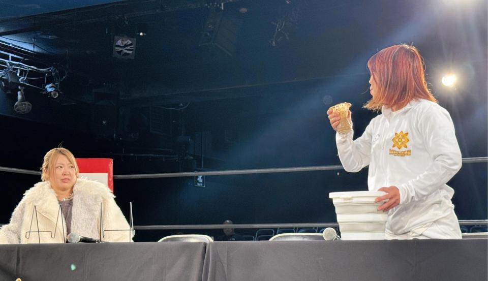 　持参した泥水をガブ飲みして挑発する石川奈青（右）とドン引きする桜井麻衣