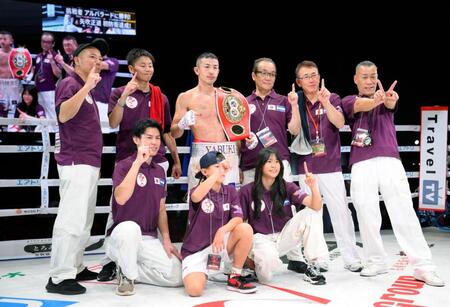 　初防衛を果たし、関係者と写真に納まる矢吹正道（中央）