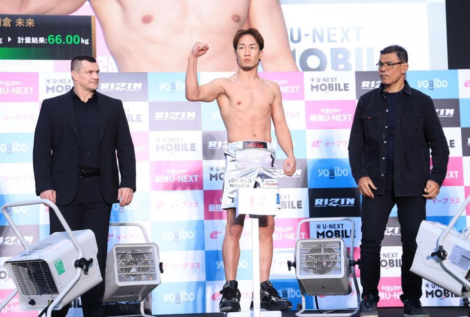 　ミルコ・クロコップ（左）、アントニオ・ホドリゴ・ノゲイラ（右）の立ち合いのもと、計量をパスしガッツポーズの朝倉未来（撮影・金田祐二）