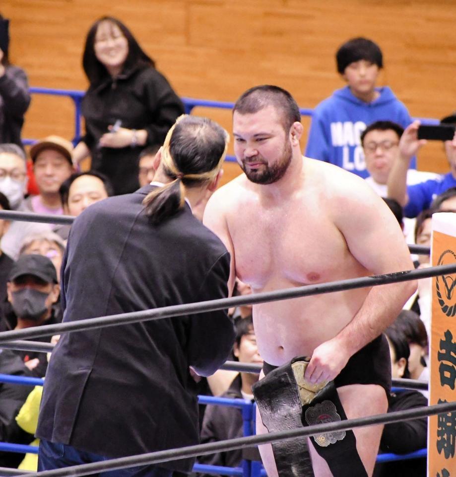 　デビュー３５周年を迎えた天山広吉（左）と握手を交わすウルフアロン