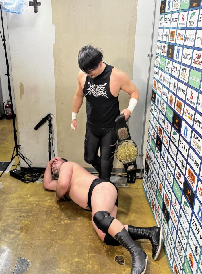 　バックステージでコメント中に成田蓮（奥）から襲撃を受けたウルフアロン