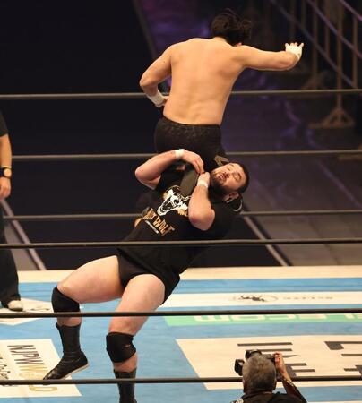 成田連（上）の攻撃を受けるウルフアロン（撮影・中田匡峻）