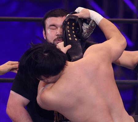 成田蓮（手前）にチャンピオンベルトで殴られるウルフアロン（撮影・中田匡峻）