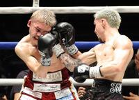 ８回、アンソニー・オラスクアガ（右）の右フックを浴び、顔をゆがめる飯村樹輝弥（撮影・西岡正）