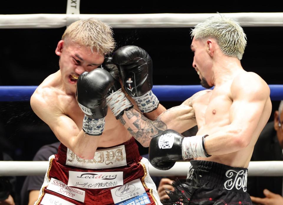 ８回、アンソニー・オラスクアガ（右）の右フックを浴び、顔をゆがめる飯村樹輝弥（撮影・西岡正）