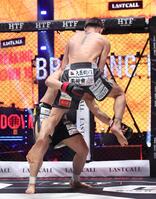 西島恭平（左）に飛び膝蹴りを浴びせるＫＩＮＧカズ（撮影・佐々木彰尚）