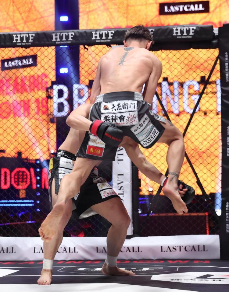 西島恭平（左）に飛び膝蹴りを浴びせるＫＩＮＧカズ（撮影・佐々木彰尚）