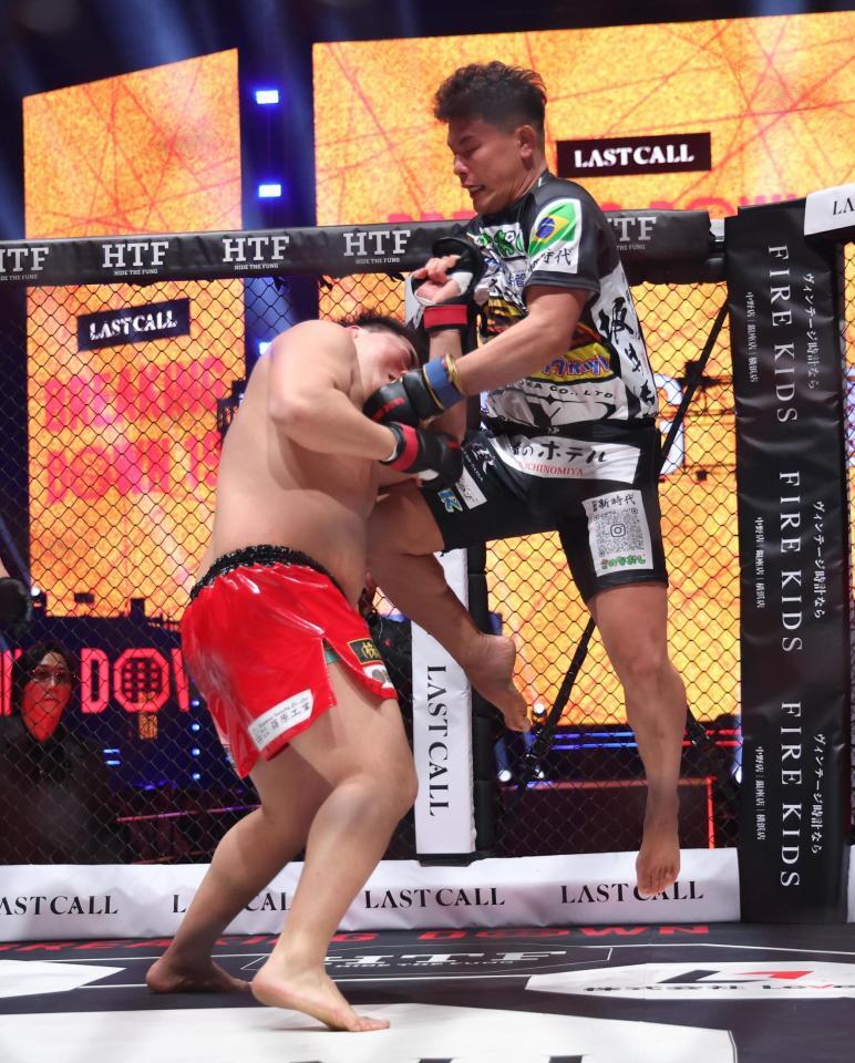 赤パンニキに膝蹴りを浴びせる金田一孝介（撮影・佐々木彰尚）