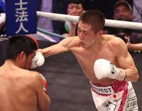 ８回、マーロン・タパレス（左）の顔面をとらえる小国以載（撮影・佐々木彰尚）