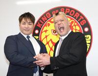 棚橋弘至社長（左）と握手をする天山広吉（撮影・佐々木彰尚）