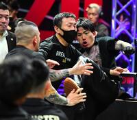 乱闘しＴシャツが破れるシェンロン（奥）と森（手前）