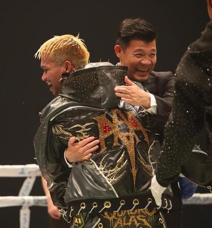ルイス・ネリとの闘いに勝利したジョン・リエル・カシメロと抱き合う亀田興毅ファウンダー（撮影・坂部計介）