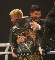 ルイス・ネリとの闘いに勝利したジョン・リエル・カシメロと抱き合う亀田興毅ファウンダー（撮影・坂部計介）