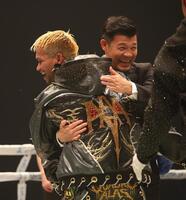 ルイス・ネリとの闘いに勝利したジョン・リエル・カシメロと抱き合う亀田興毅ファウンダー（撮影・坂部計介）