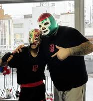 レイ・ミステリオのマスクをかぶってポーズを取るエリック・バディージョ（左）と実弟のイバン・バディージョトレーナー