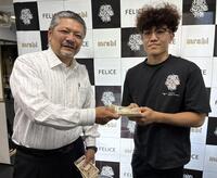 枝川会長（左）から報償金を受け取る中山慧大
