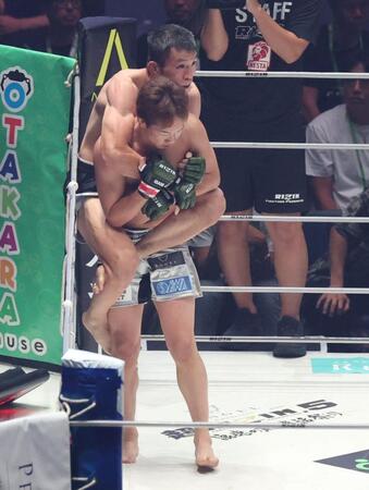 １Ｒ、朝倉未来（手前）の背後を取る青木真也（撮影・中田匡峻）