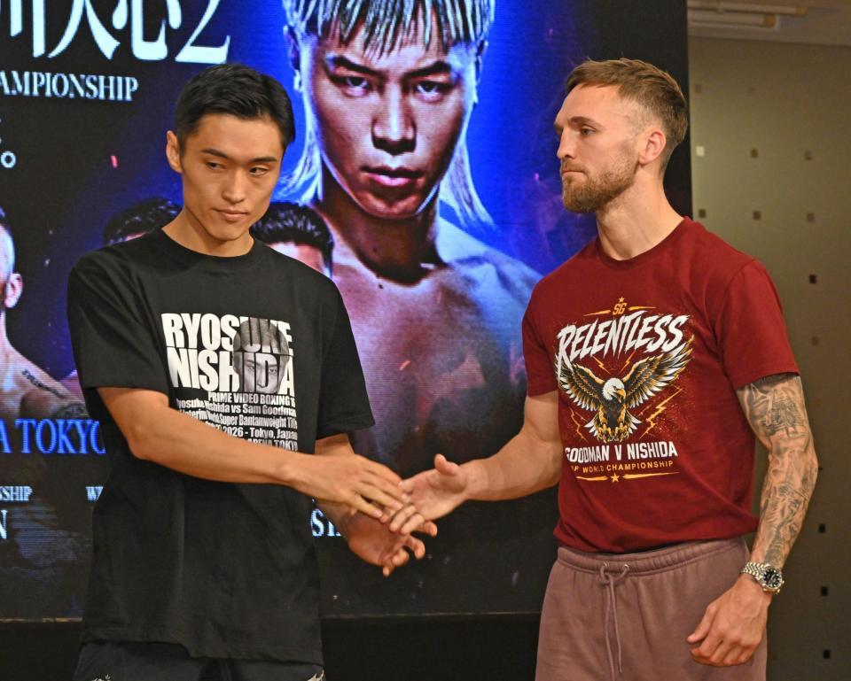 写真撮影を終え握手する西田凌佑（左）とサム・グッドマン