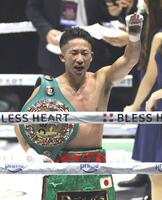 タイトルを防衛し、観客席に向かって手を上げる井上拓真（撮影・西岡正）