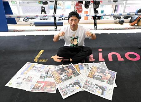 那須川天心戦を報じる各スポーツ新聞を前にポーズを決める井上拓真（撮影・堀内翔）