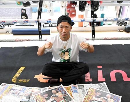 　那須川天心戦を報じる各スポーツ新聞を前にポーズを決める井上拓真（撮影・堀内翔）