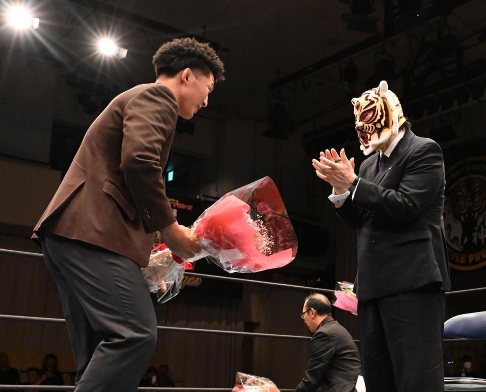 佐山サトル（右）に花束を贈呈するレスリング・日下尚