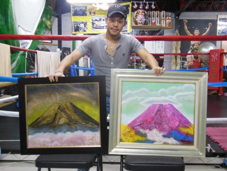 　自身が描いた２枚の富士山の油絵を手にする亀田興毅