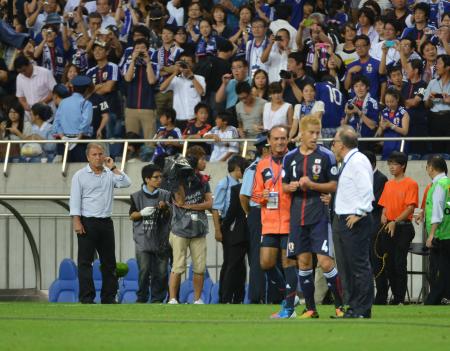 　試合後、ピッチで話し込むザッケローニ監督（右）と本田を見つめるジーコ監督（左端）＝撮影・出月俊成