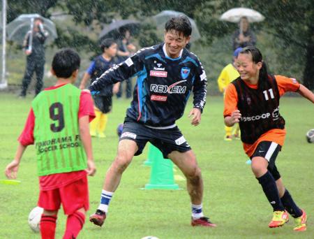 　サッカー教室で小学生とボールを追う横浜ＦＣの三浦＝あづま総合運動公園