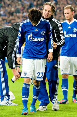 　アーセナル戦の前半、負傷交代でベンチに下がるシャルケの内田＝ゲルゼンキルヘン（共同）