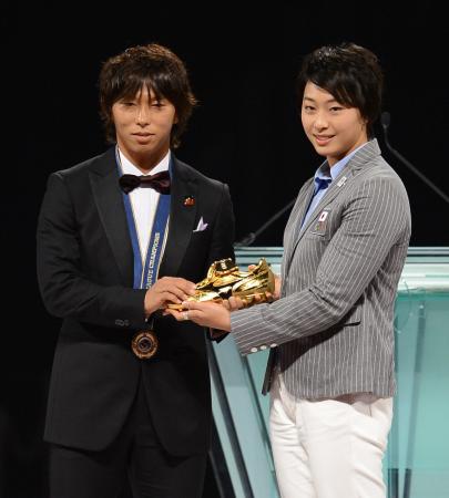 　得点王に輝き、プレゼンターの鈴木聡美（右）からゴールドシューズを受け取る広島・佐藤