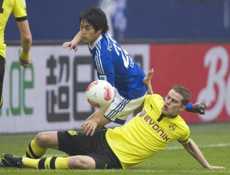 　ドルトムント戦の前半、競り合うシャルケの内田（奥）＝ゲルゼンキルヘン（共同）
