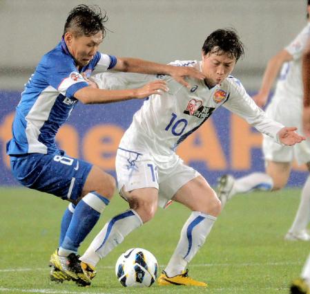 　仙台‐江蘇　後半、競り合う仙台・梁勇基（右）＝南京（共同）