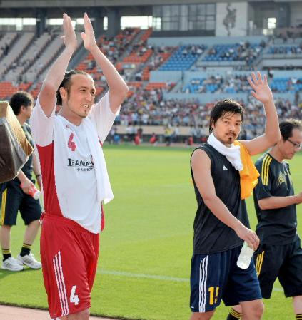 　試合後にサポーターの声援に応えるＪリーグ選抜の闘莉王（左）とＴＥＡＭ　ＡＳ　ＯＮＥの松井