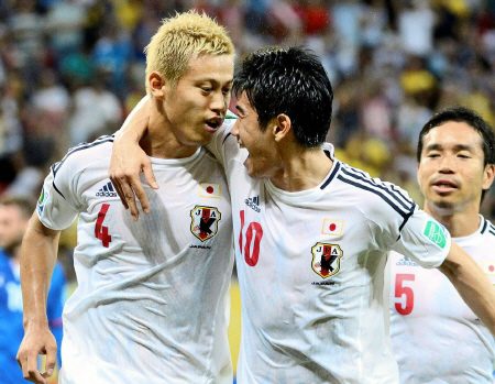 前半、先制点を決めた本田（左）と抱き合って喜ぶ香川（共同）