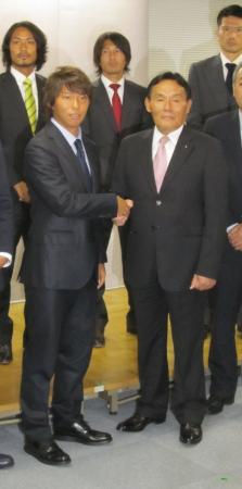 　労使協議会を終え握手する日本プロサッカー選手会の佐藤会長（左）と大東チェアマン