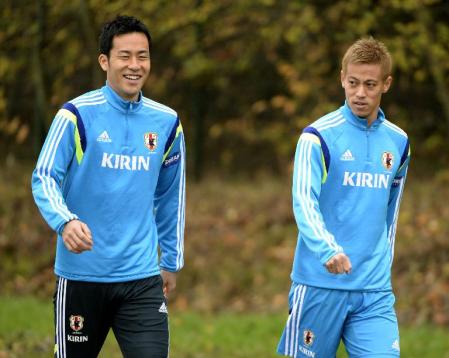 　笑顔でゲンクでの初練習に臨む吉田（左）と本田（共同）