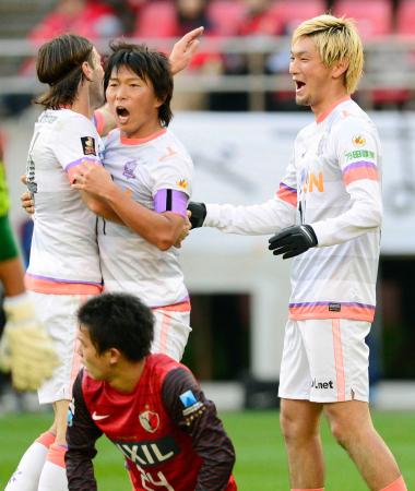 　前半終了間際、３点目のゴールを決め、佐藤（中央）らと喜ぶ広島・高萩（右）