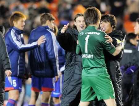 　うなだれるＦＣ東京イレブンの手前で広島ＧＫ西川をねぎらうＭＦミキッチ（左）と佐藤（右）