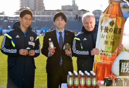 キリンのマーケティング部商品担当部長の丸岡俊哉さん（中央）から紅茶とおにぎりの差し入れを受ける香川（左）とザッケローニ監督（撮影・吉澤敬太）