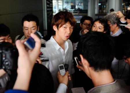 　帰国後、報道陣の質問に答える大迫（中）＝撮影・西岡　正