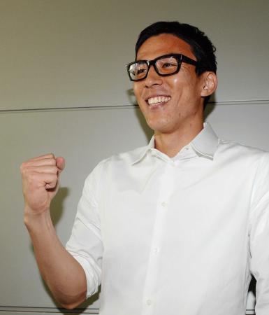 　帰国し、笑顔でガッツポーズする長谷部（撮影・西岡　正）