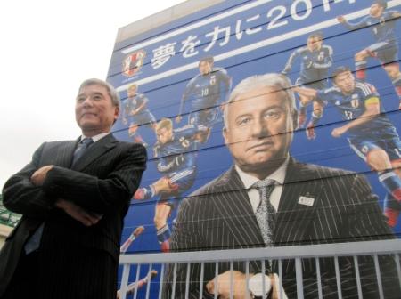 　日本サッカー協会ビルの壁面装飾の前でドヤ顔をする大仁邦彌会長