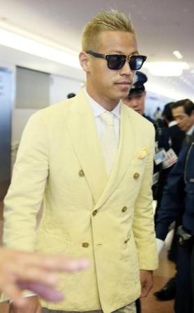 　黄色いジャケットにサングラス姿で帰国した日本代表の本田圭佑＝21日午後、羽田空港