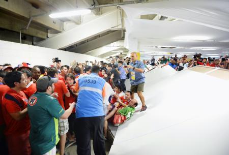 　試合開始前にマラカナン競技場に乱入したチリサポーター。右は壊された壁＝１８日、リオデジャネイロ（共同）
